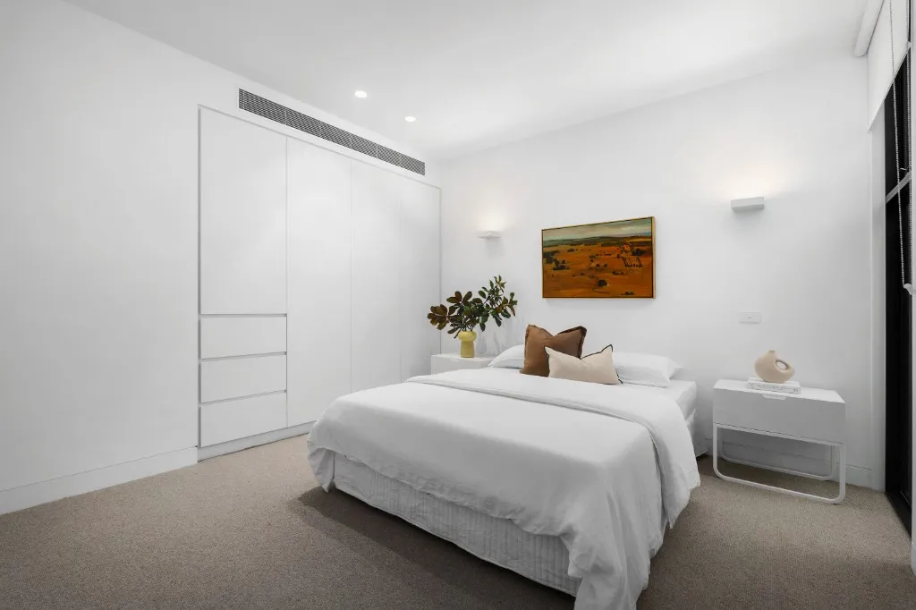 Built-in wardrobe with white handleless doors and integrated drawers