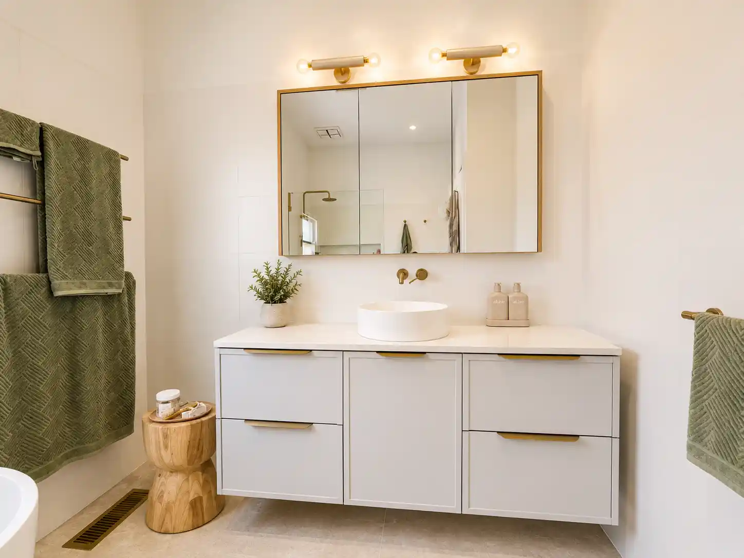 Three-drawer vanity with stone top and brass pulls
