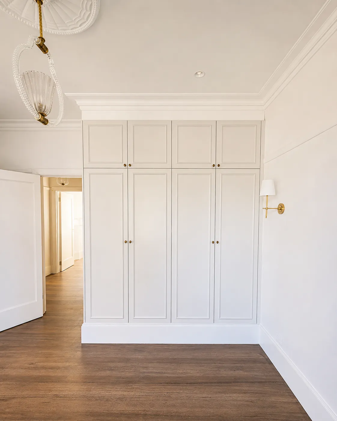 Floor-to-ceiling shaker wardrobe with brass hardware